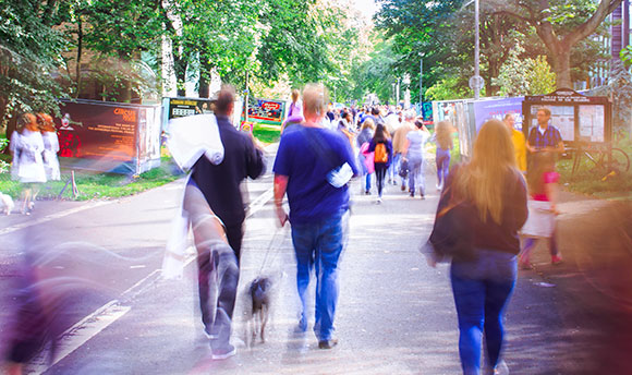 PBlurry image of a busy street, centred is a couple walking a dog, Edinburgh