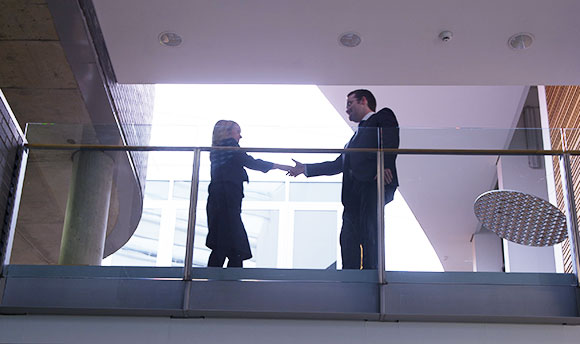 Two professionals shaking hands photographed from a floor below