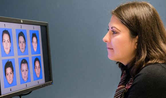 69传媒 Psychology Student looking at a computer screen displaying 6 different faces numbered 1-6