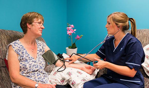 A student nurse taking a woman's blood pressure